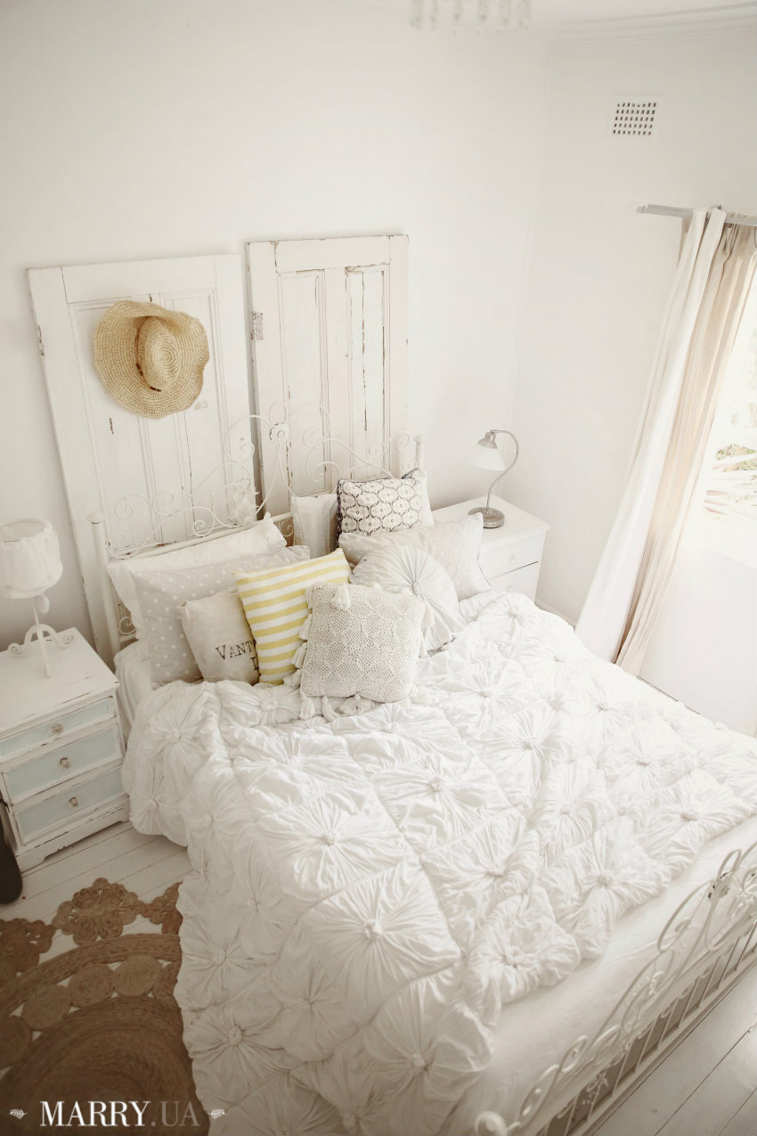 coastal-bedroom-shabby-vintage-beachy-chic-abeachcottage.com-blog-whitewashed-floors-casual-jute-rug-vintage-doors-linen-curtains-white-bedding-striped-pillows
